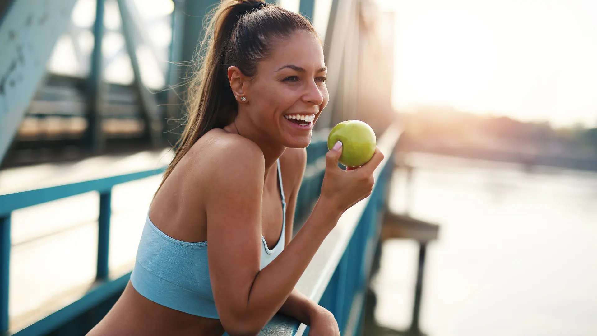 Woman Holding an apple for jaw health and overall oral health.
