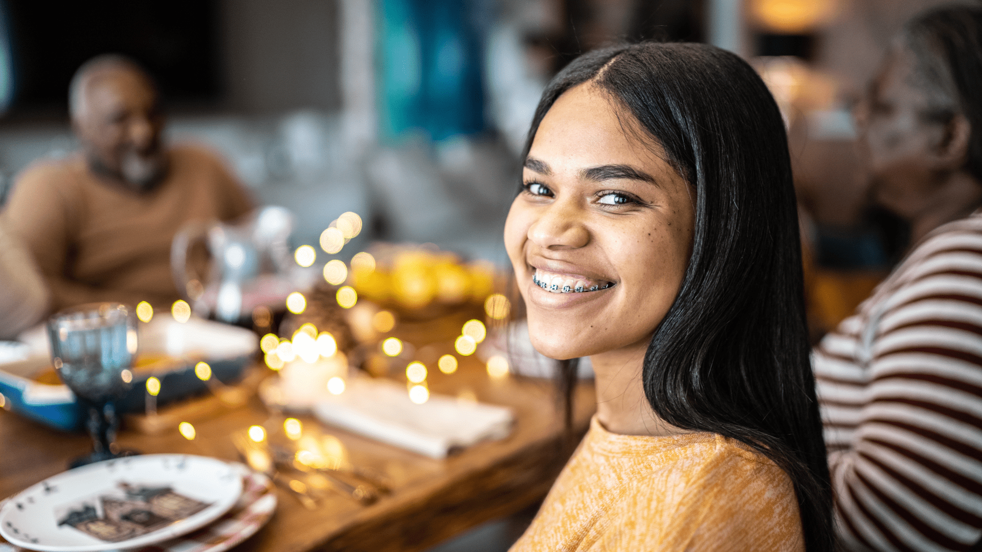 girl smiling with braces, a treatment from one of the best orthodontists in Detroit. Learn more about what holiday foods to avoid with braces.
