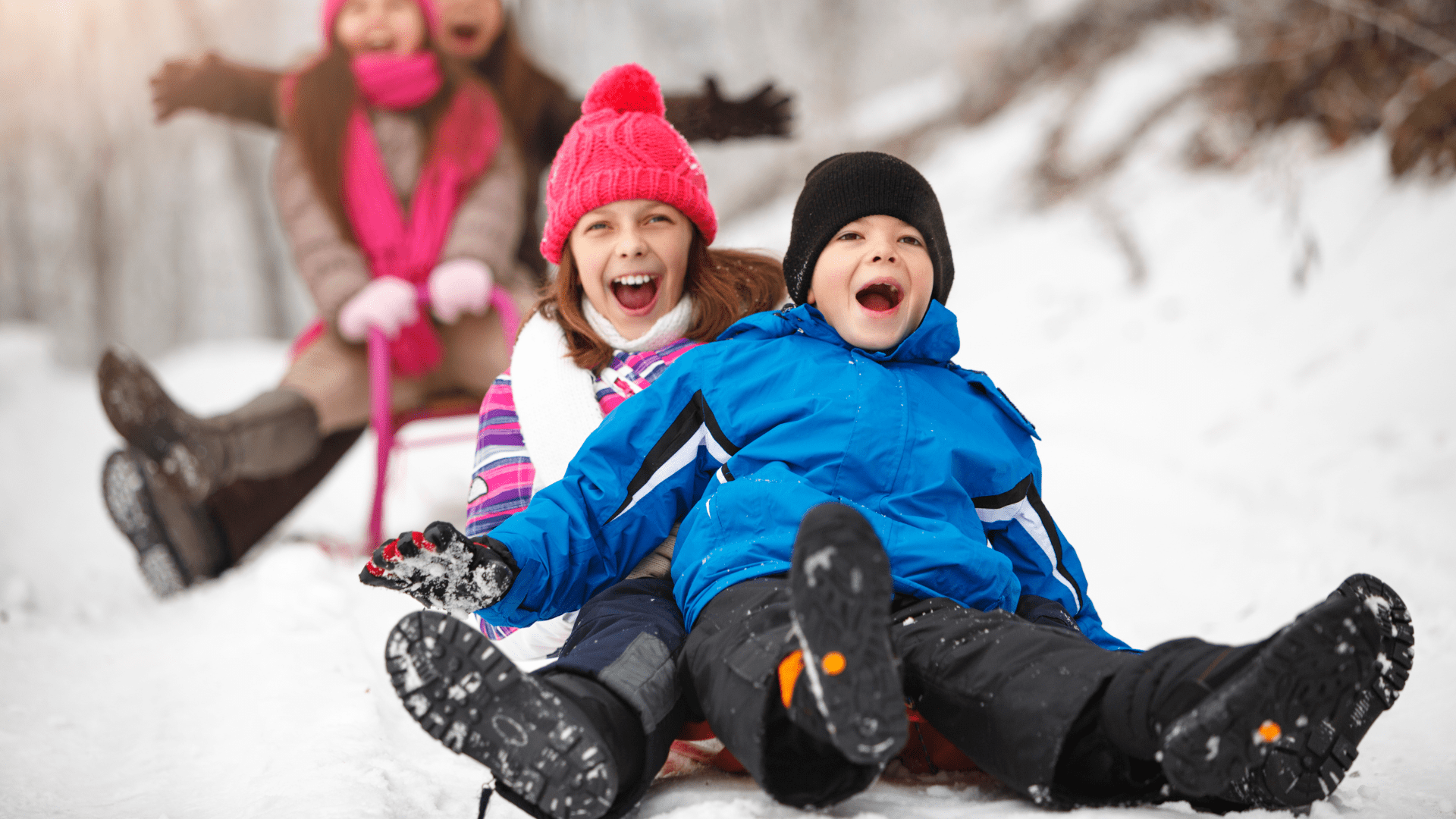 Children sledding down a snowy hill after getting orthodontic treatment from dr daia