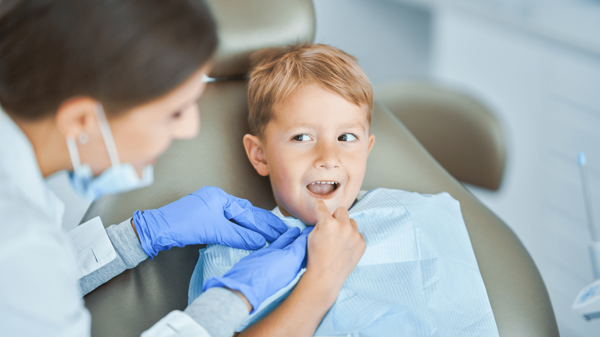 A dental professional wearing blue gloves examining a young patient seated in a dental chair at Daia Orthodontics.